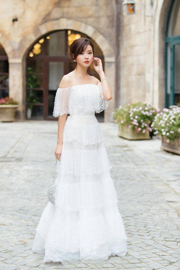 街拍:白色连衣裙穿出了美女的好身材,撩发的姿势也很是动人