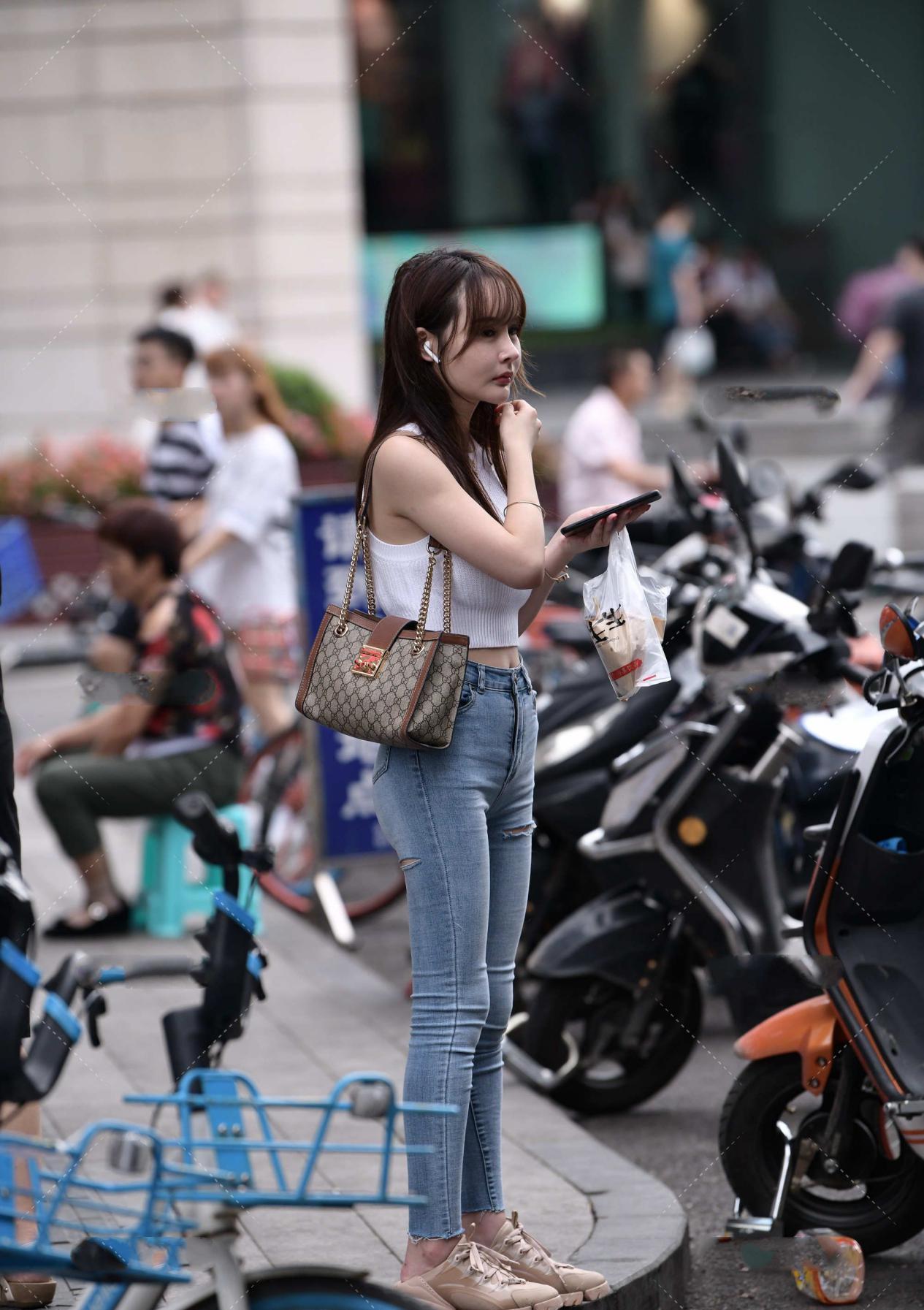 浅色牛仔裤的多种搭配方式,与白色背心组合,经典时尚