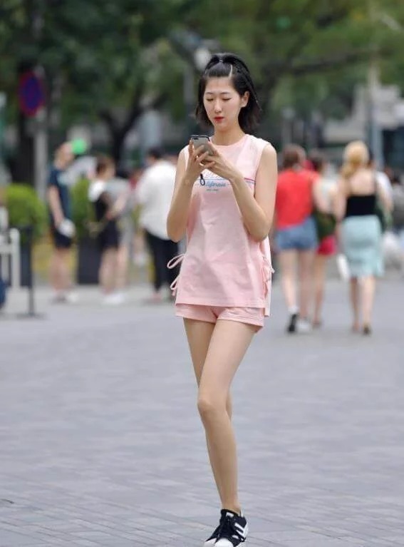 长裤|街拍:身材高挑的美女,身穿吊带配牛仔长裤,时尚优雅美丽大方