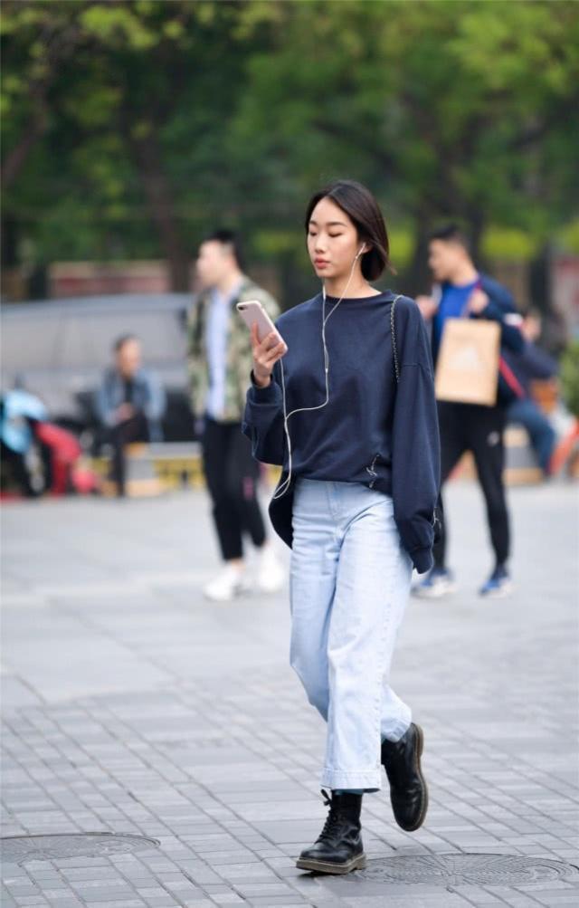 街拍时尚大气的美女,简洁的吊带背心搭配牛仔裤,显得十分修身立体