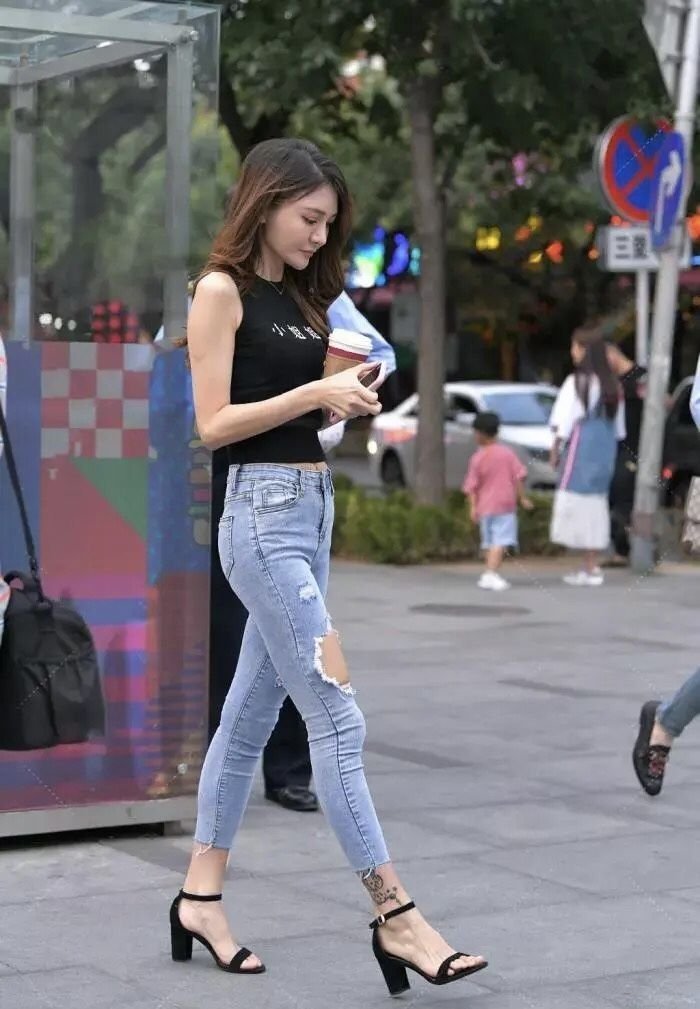 美女|美女街拍:无袖上衣配破洞牛仔裤,这样时髦个性穿搭,显得美女青春范十足