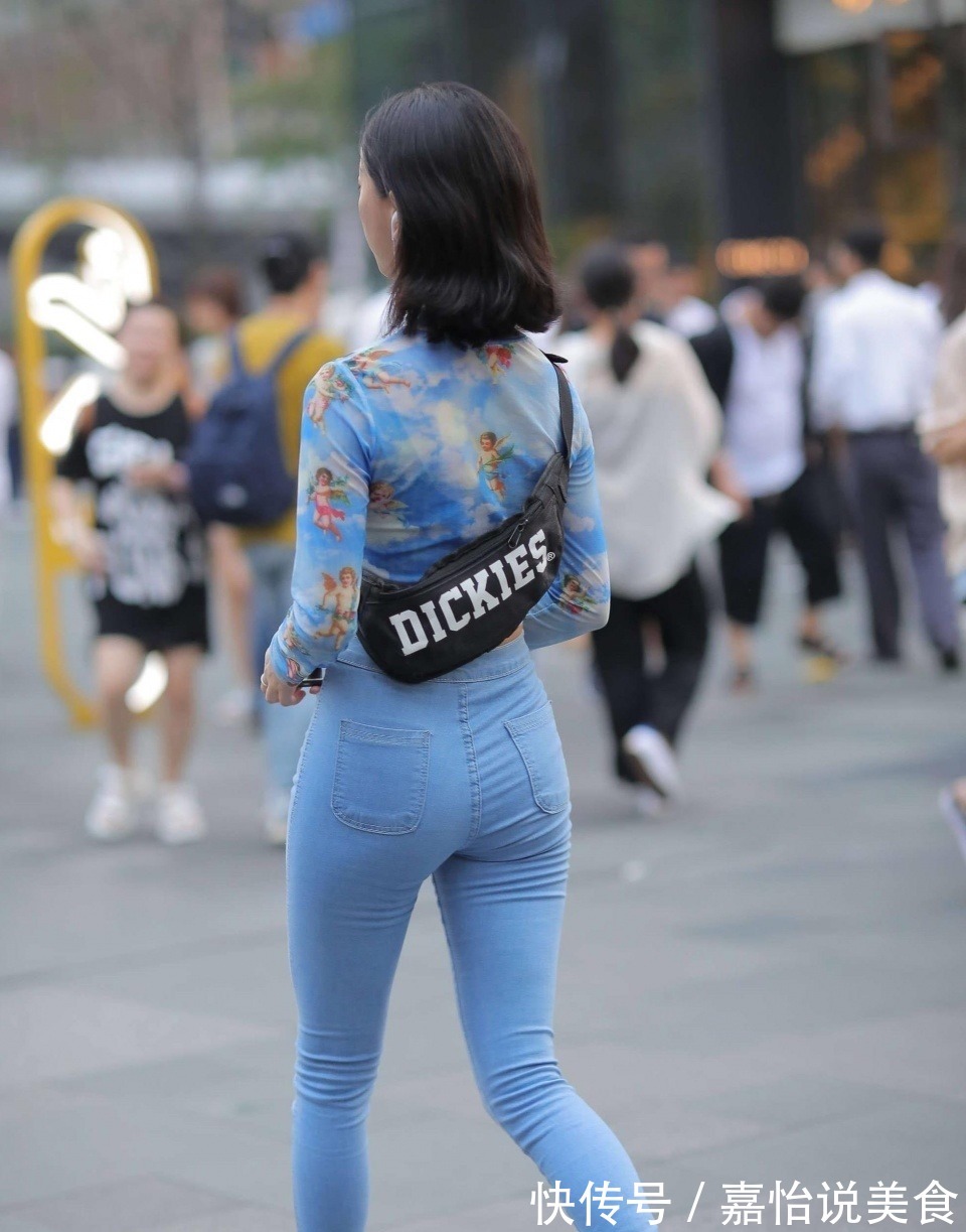 紧身牛仔裤 小姐姐身穿蓝色紧身牛仔裤,搭配一件扎染的上衣,看上去很时尚