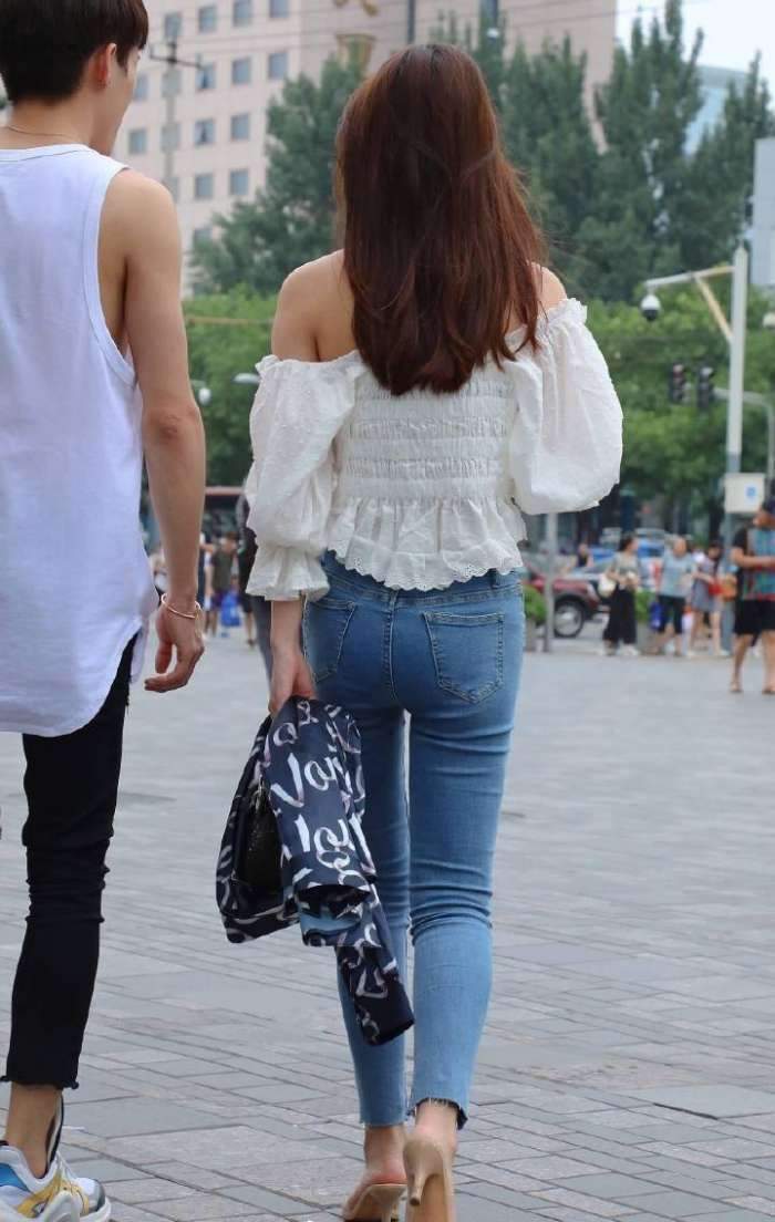 展现|街拍:美女穿着白色的抹胸上衣搭配牛仔裤,美腿曲线完美的展现!