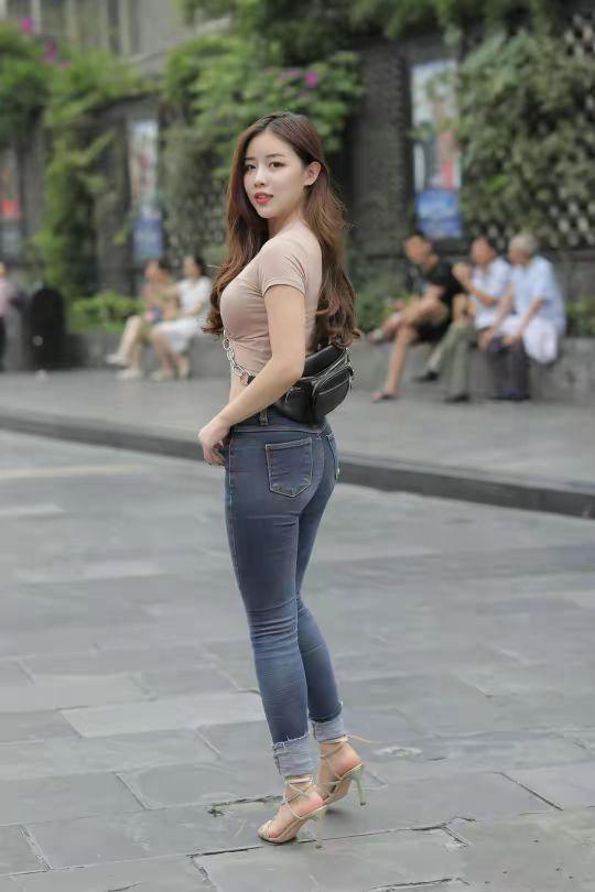 妹子 高腰紧身牛仔裤,淡茶色T恤,这样穿衣装扮的妹子,看上去时尚吗?