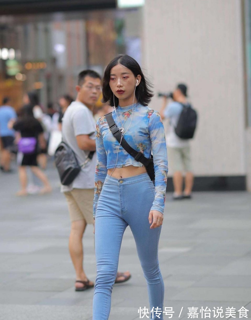 紧身牛仔裤 小姐姐身穿蓝色紧身牛仔裤,搭配一件扎染的上衣,看上去很时尚