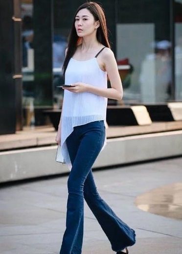街拍:长发美女身穿吊带上衣,不规则下摆平稳走线,优雅范十足