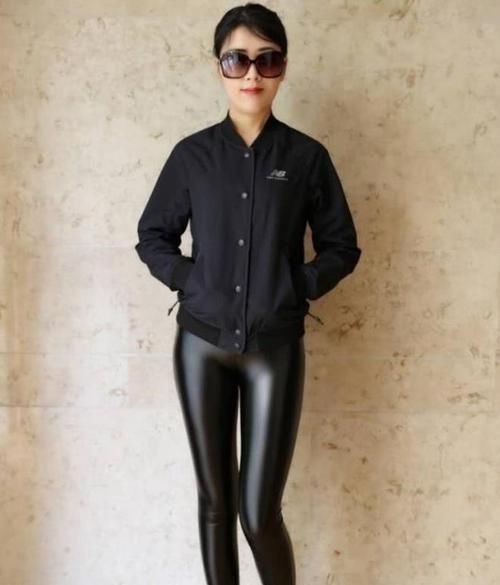 街拍小姐姐身穿一件白色短袖紧身T恤,搭配一条黑色牛仔短裤