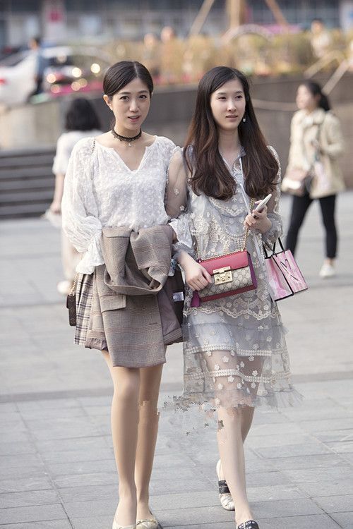 街拍：一起逛街的短发美女，分别穿白色的纱裙与蓝色牛仔裙，美动减龄