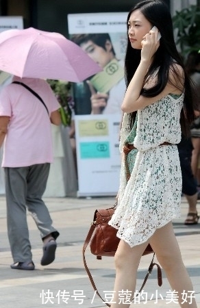 街拍:打电话的美女穿一身镂空连衣短裙,突显清秀潮流气息