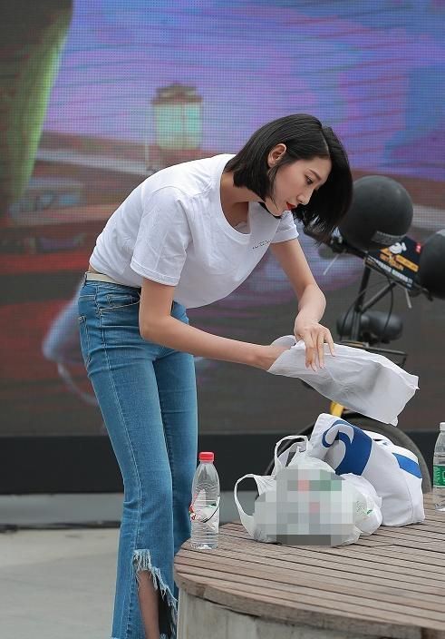 街拍:图六身材棒,白T恤搭牛仔裤,街上弯腰整理物品都这么迷人