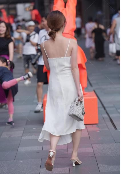 吊带连衣裙，配上高跟鞋和灰色包包，显示出了美女的“青春气质”