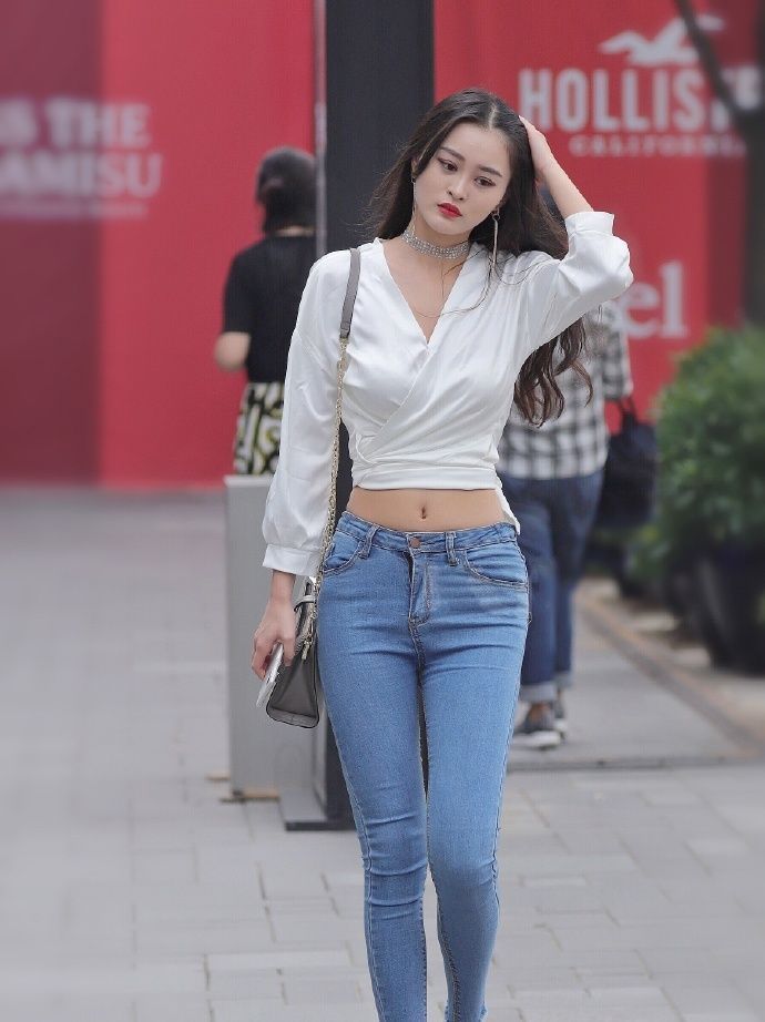 街拍|街拍:蓝色牛仔搭配白色上衣,天鹅颈小姐姐自信美丽