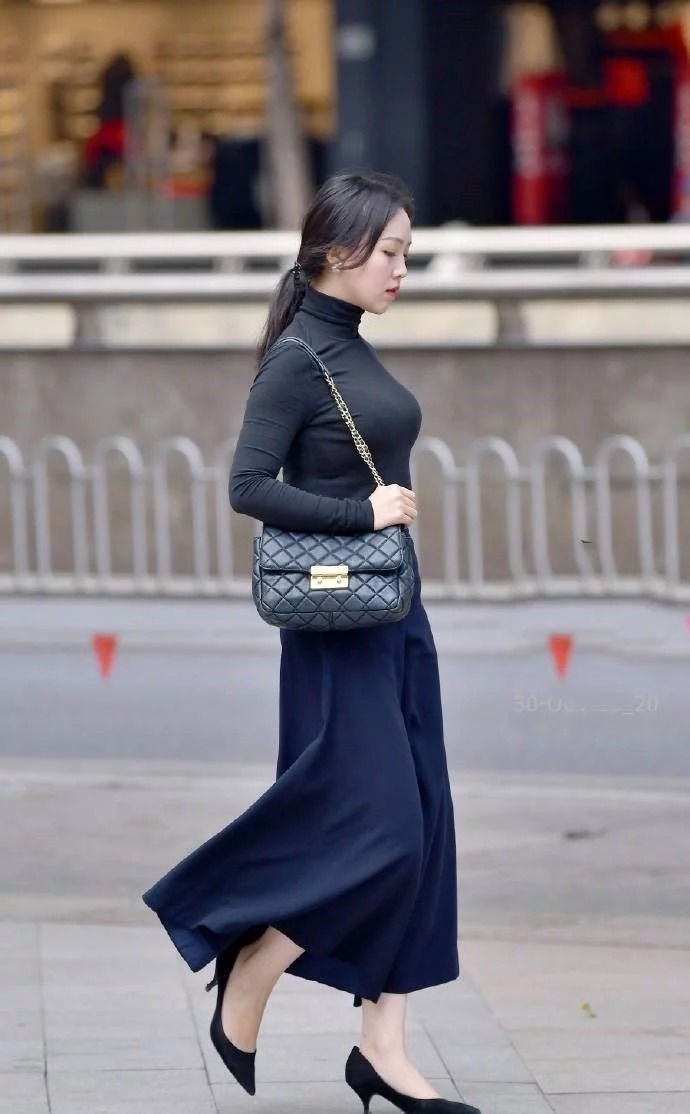 街拍:小姐姐身穿红色无袖上衣,白色的长裤,造型很时尚