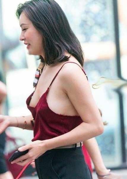 街拍小姐姐身穿红色吊带背心性感娇艳,搭配休闲裤帅气又随性