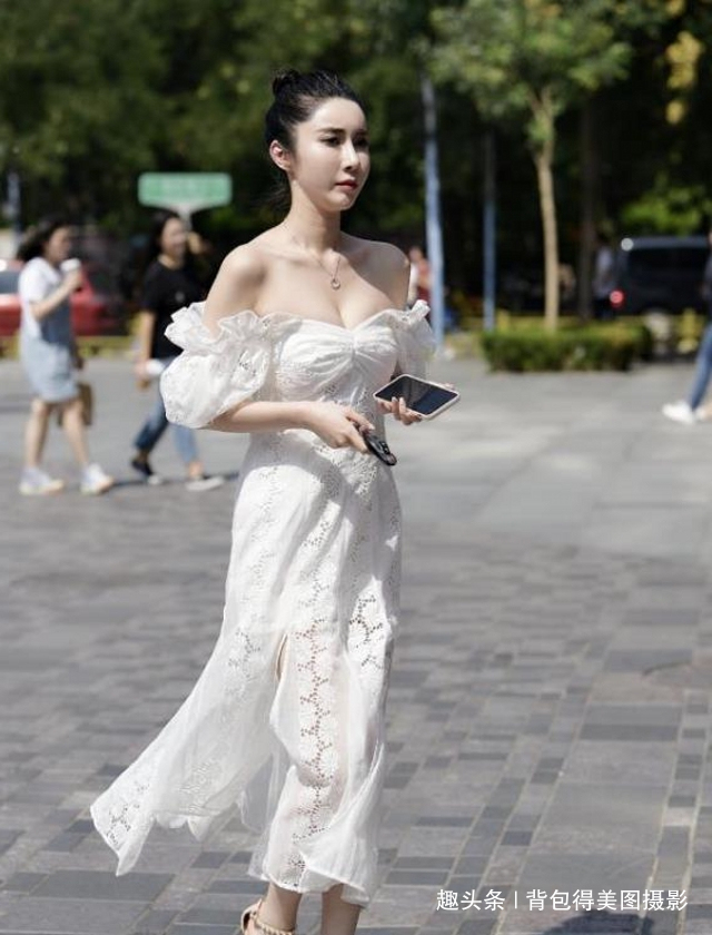 女生们|路人街拍,美女选择一款米白色的露肩连衣裙,时尚又有女神范