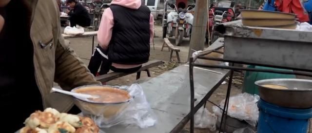 一位65岁老汉在大集卖小吃,露天柴火烧,顾客大老远跑来吃