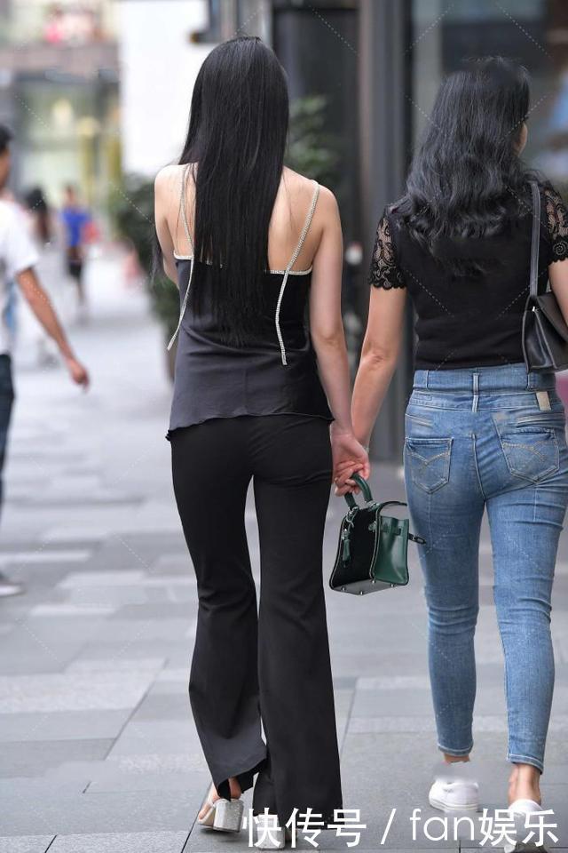 小姐姐黑色喇叭裤搭配了一件吊带衫,展现出了几分随性慵懒的格调