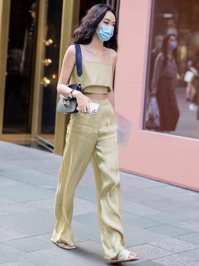 小姐姐穿着纯白色背带连衣裤，显得时尚大方