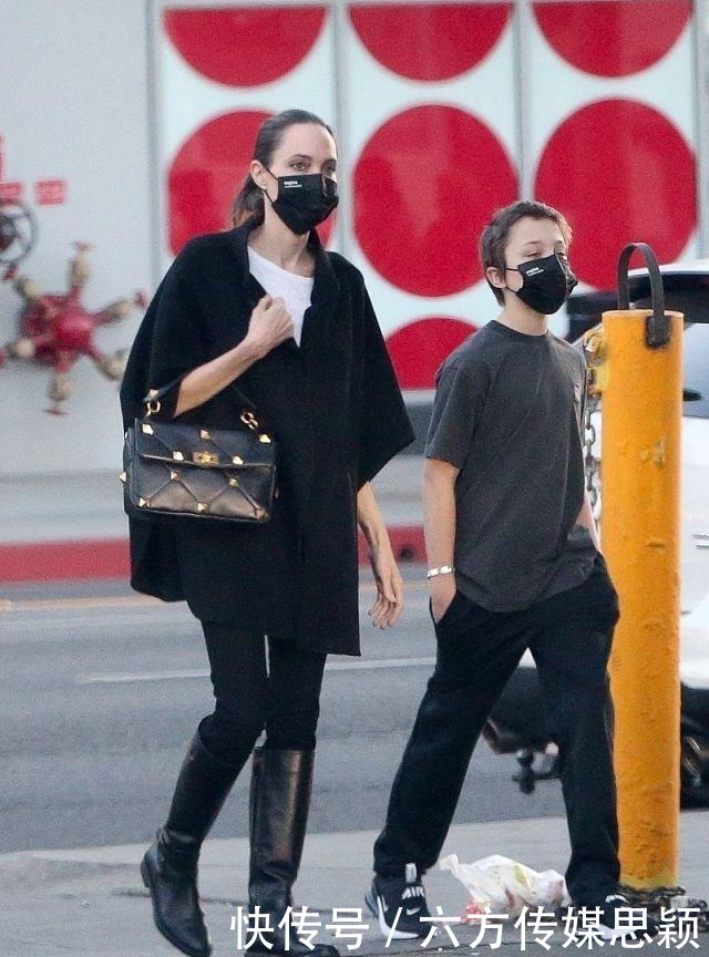安吉丽娜·朱莉穿黑色斗篷上衣搭配细腿裤,和儿子逛街,真潇洒