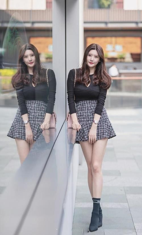 着黑色修身上衣搭配高腰短裙，温婉大方，貌美如花