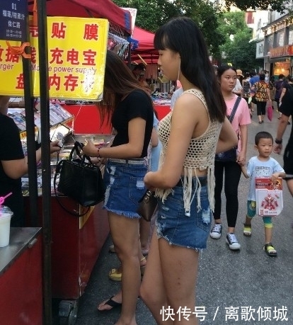 镂空|街拍:美女蓝色紧身高腰牛仔裤搭镂空线衣,给人时尚清凉的感觉