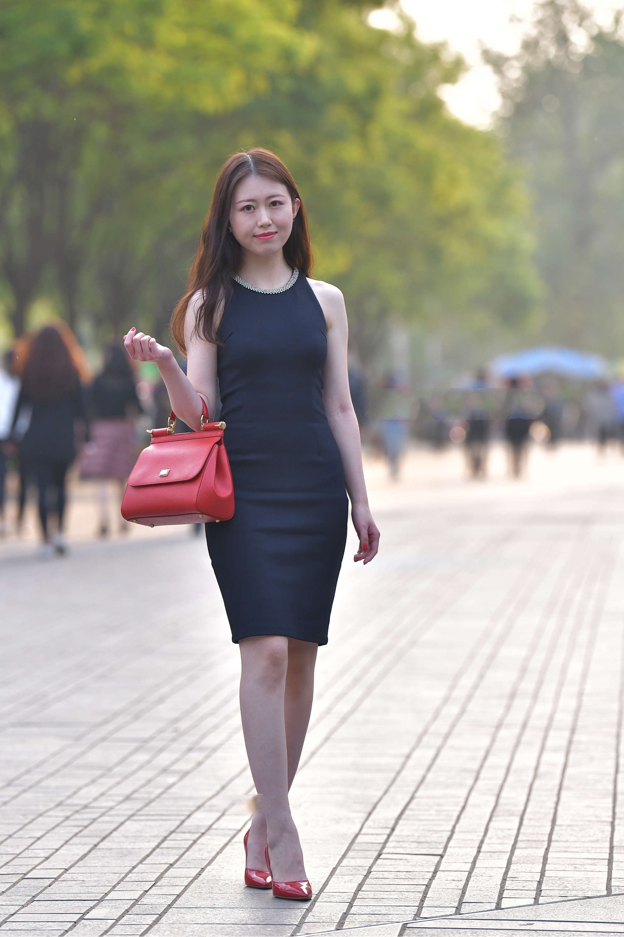 黑色修身款连衣裙搭配红色手提包,大方精致,凸显时尚丽人感