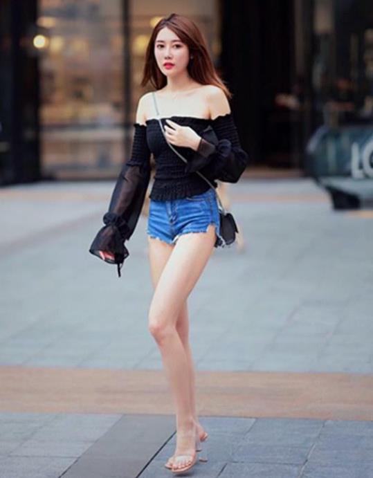 牛仔|街拍小姐姐黑色露肩上衣搭配一条紧致的牛仔短裤,很有少女范
