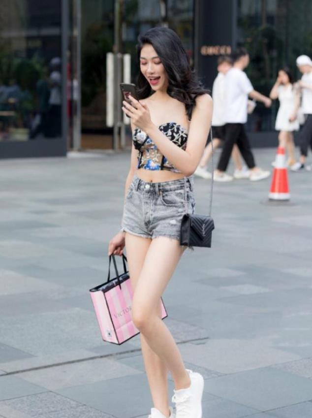 牛仔|街拍小姐姐黑色露肩上衣搭配一条紧致的牛仔短裤,很有少女范