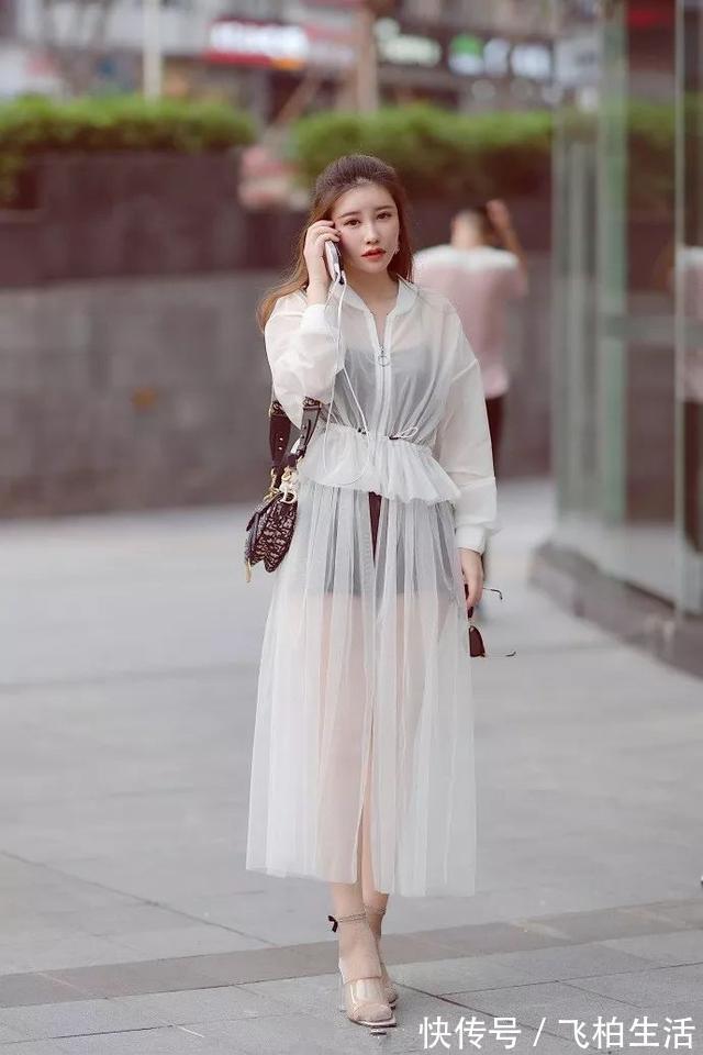 衬衫 小姐姐身穿宽松衬衫,搭配鲜艳的印花半身裙,显得格外的靓丽