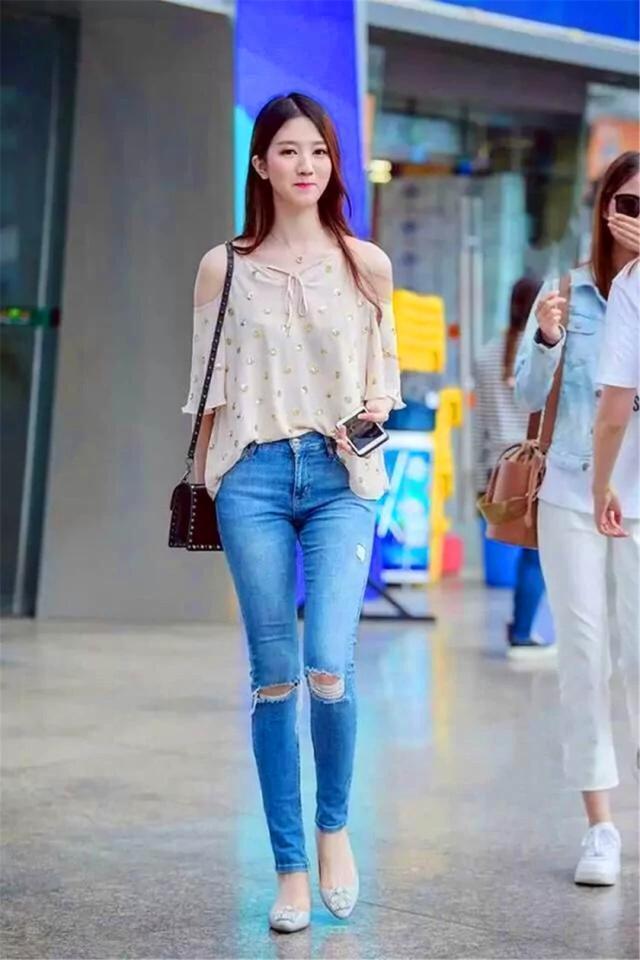 街拍穿紧身破洞牛仔裤的小姐姐,清秀的长相,看起来很是养眼