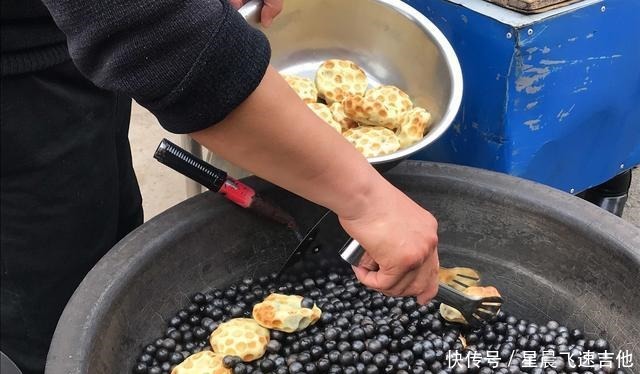 乡村年集上 一男子手拿一把铁锹在石头子上做美食 日进千元