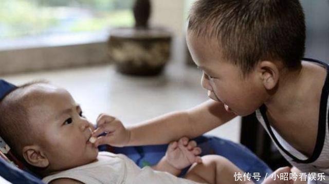 偷吃|弟弟见姐姐看电视入迷,趁机偷吃她手中鸡腿,被发现后表情萌翻