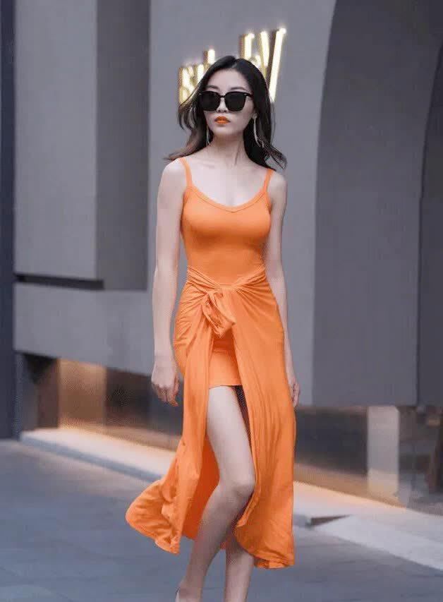 街拍小姐姐身穿橘子色连衣长裙,更显青春靓丽的气质
