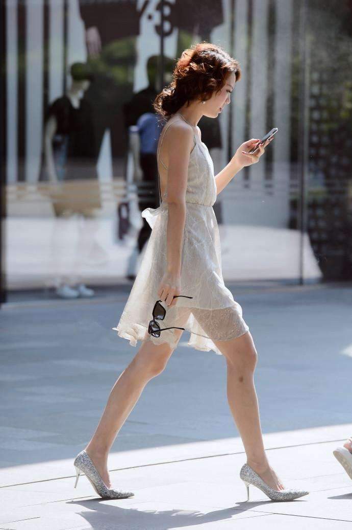 各式各样|街拍:美女穿着一身亮片材质的吊带连衣裙,走在街上十分引人注目