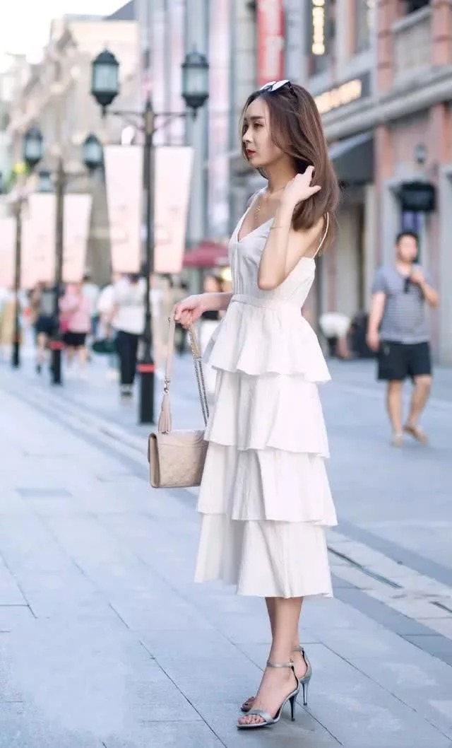 牛仔裤|街拍:肤如凝脂的美女,身穿白色背心配浅色牛仔裤,青春靓丽气质