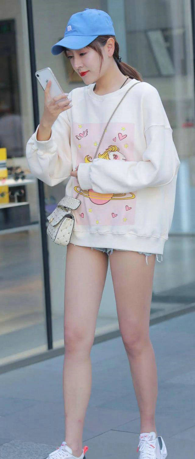 街拍|美女街拍:美女选择了一条粉色牛仔裙,款式时尚新颖,穿出了满满的青春动感