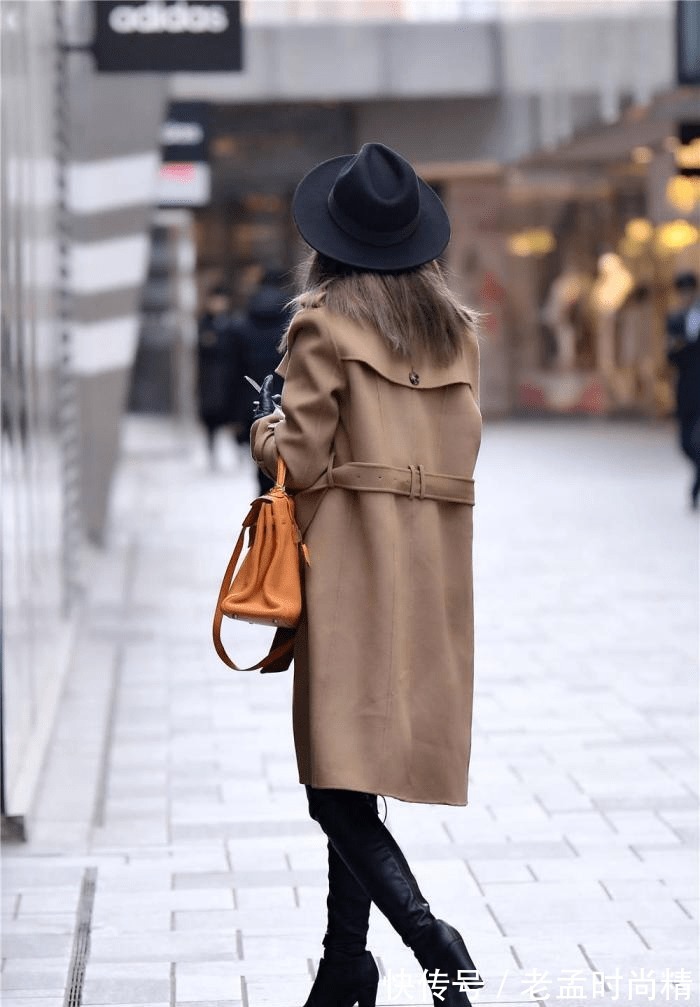 身材高挑 棕色呢子大衣,搭配黑色过膝皮靴,粗跟款式,衬托身材