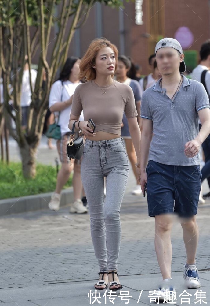 街拍紧身衣搭配灰色牛仔裤裹的很严实,衣摆设计展现精致小蛮腰