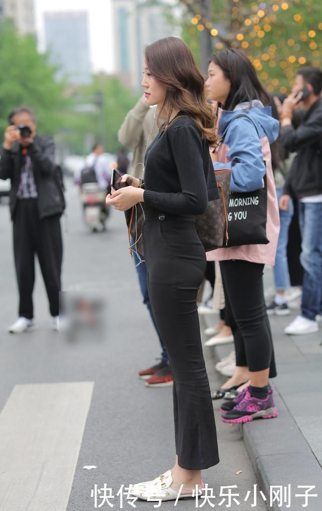 黑色的紧身T恤,搭配黑色喇叭裤,凸显出十足的女人味
