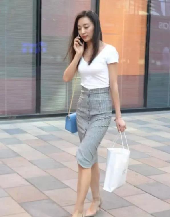 街拍丰标不凡的美女,白色短袖配黑色长裤,女神范十足