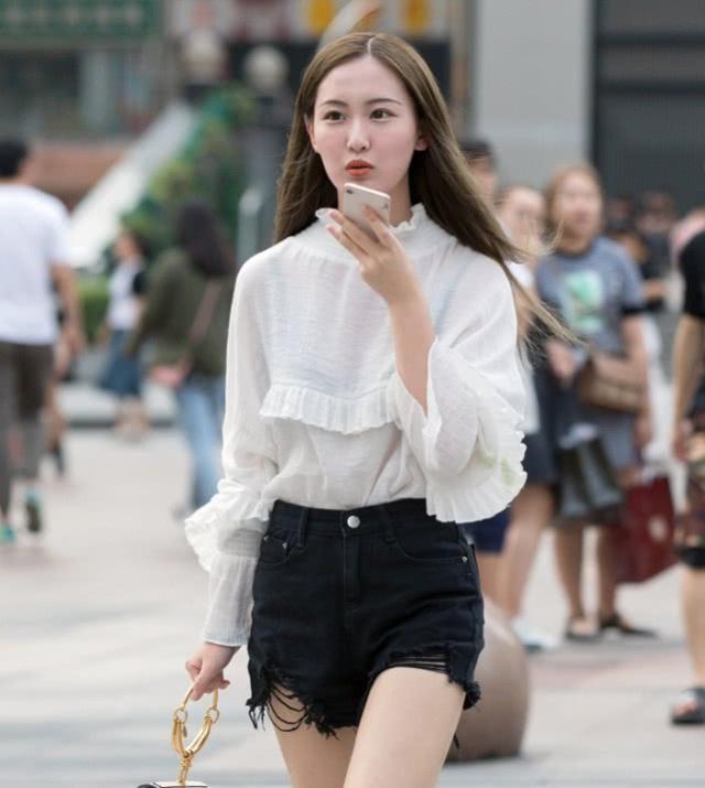 街拍:美女身穿黄色毛衣搭配小皮裙,笑容甜美可爱,非常时髦