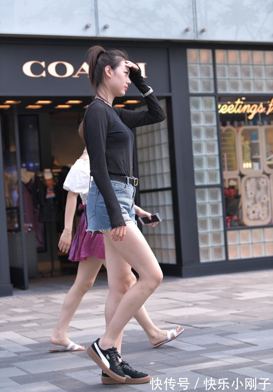高女孩|小姐姐身穿黑色的长袖,搭配黑色的牛仔短裤,走在街上很时尚大方
