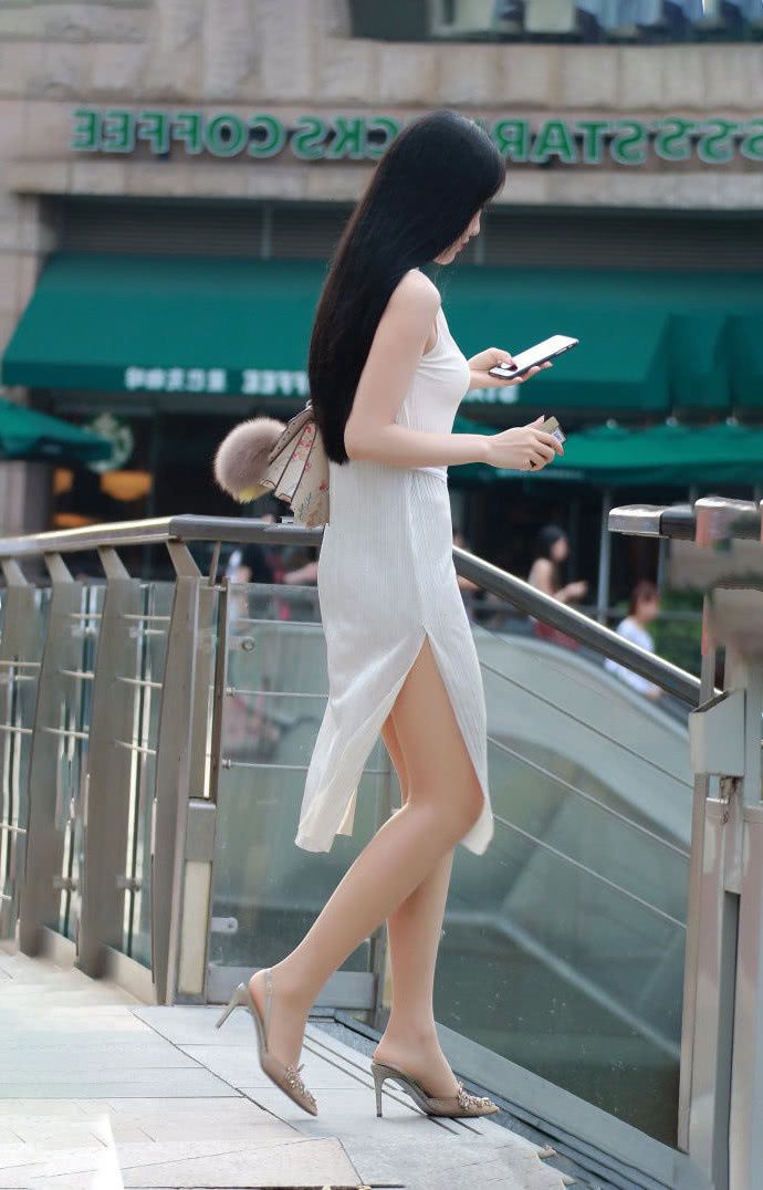 街拍小姐姐白色性感开叉连衣裙,尽显优美曲线跟大长腿