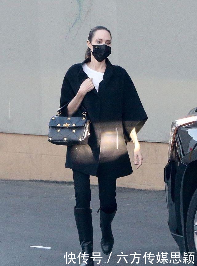 安吉丽娜·朱莉穿黑色斗篷上衣搭配细腿裤,和儿子逛街,真潇洒