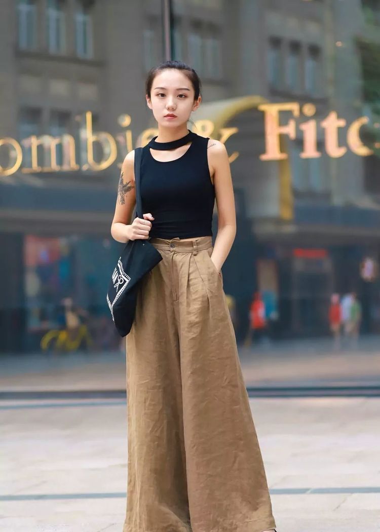 短裤|戴眼镜的美女，身穿吊带搭配黑色短裤，大秀修长美腿