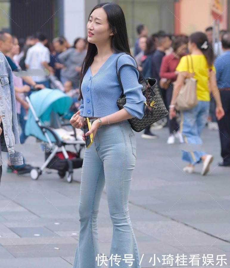 蓝色v领针织开衫搭配浅色喇叭裤,拉长身材比例,展现独特气质