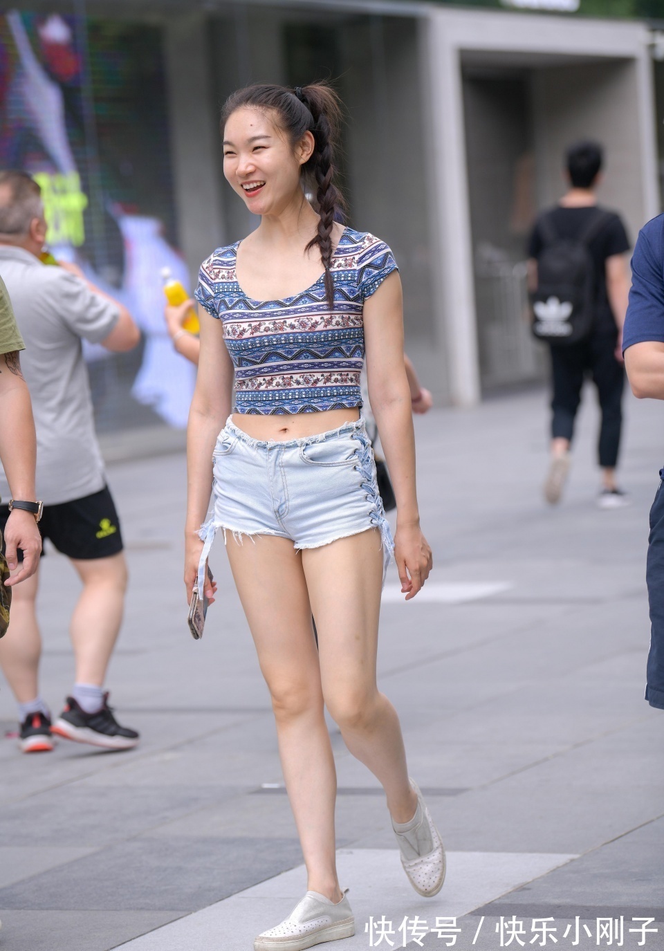 牛仔短裤|笑容灿烂的小姐姐，身穿有特色的短袖，搭配牛仔短裤，和朋友一起逛街显得很时尚