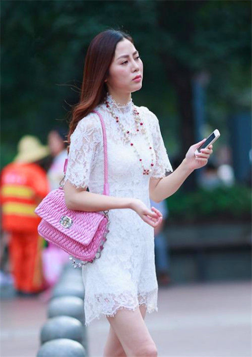 街拍气质美女穿白色镂空短裙,长发披肩,尽显苗条身姿