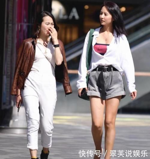 街拍小姐姐休闲款的白色黑袖上衣搭配精致的黑色短裙,美感十足