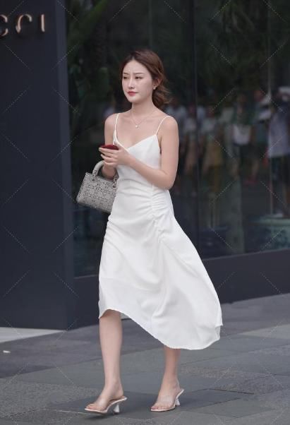吊带连衣裙，配上高跟鞋和灰色包包，显示出了美女的“青春气质”